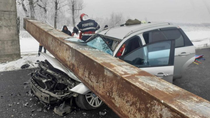 (FOTO/VIDEO) Accident de GROAZĂ în România. O femeie a murit strivită într-o mașină peste care a căzut o grindă metalică ruptă de un TIR. Două persoane, transportate la spital 