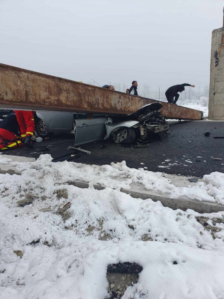 (FOTO/VIDEO) Accident de GROAZĂ în România. O femeie a murit strivită într-o mașină peste care a căzut o grindă metalică ruptă de un TIR. Două persoane, transportate la spital 