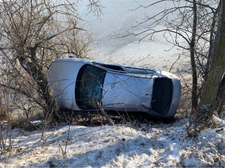 (FOTO) Un tânăr de 22 de ani, la un pas de tragedie. A pierdut controlul asupra volanului şi a zburat cu maşina pe malul unui râu